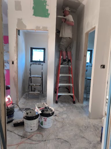 Park Avenue technician finishing drywall in a utility area during a Florida home renovation where whole-house plumbing upgrades are underway